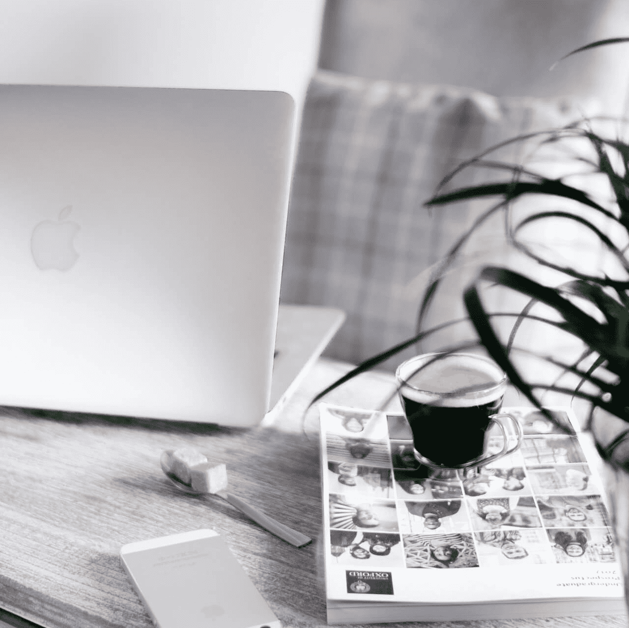 a cup of coffee on a book and a phone on a table