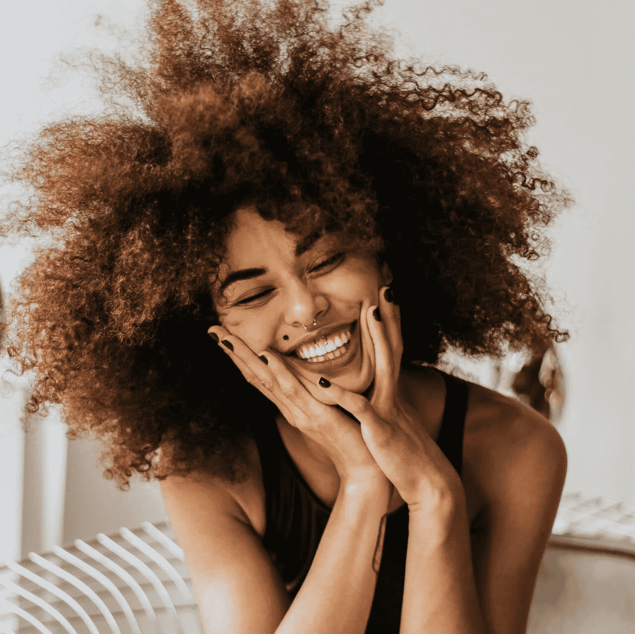 a woman with curly hair laughing