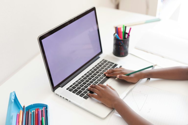 Hands of african american girl at desk using laptop with copy space for online school lesson